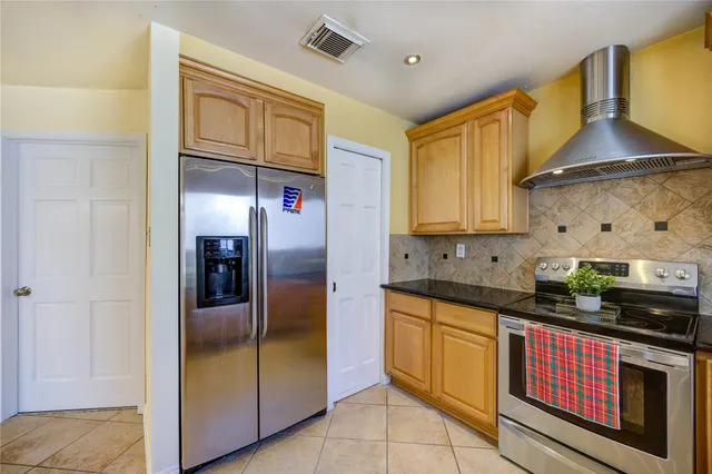 a kitchen with stainless steel appliances granite countertop a stove a sink and a refrigerator