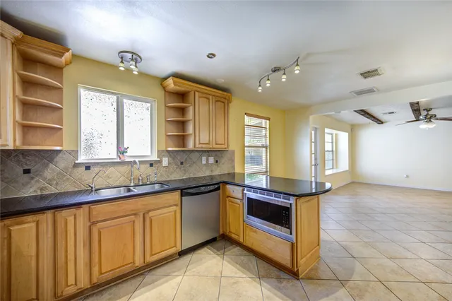 a large kitchen with granite countertop a sink and cabinets