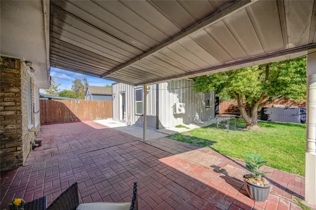 a backyard of a house with a garden and outdoor seating