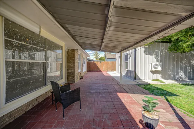 a view of a patio with table and chairs with wooden floor and fence