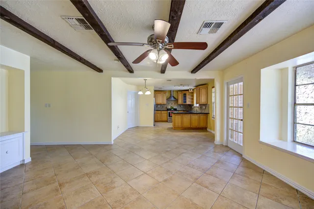 a view of an empty room with window and cabinet