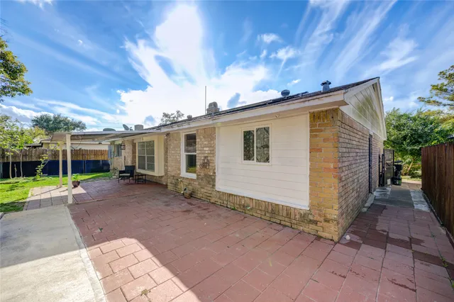 a view of a house with backyard and sitting area