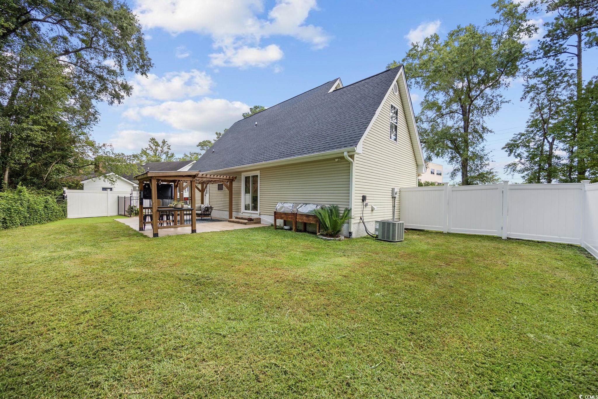 118 Sly Fox Trail Myrtle Beach, SC 29588 - Photo 31 of 40 Rear view of property featuring a fenced backyard, roof with shingles, a patio, and a pergola