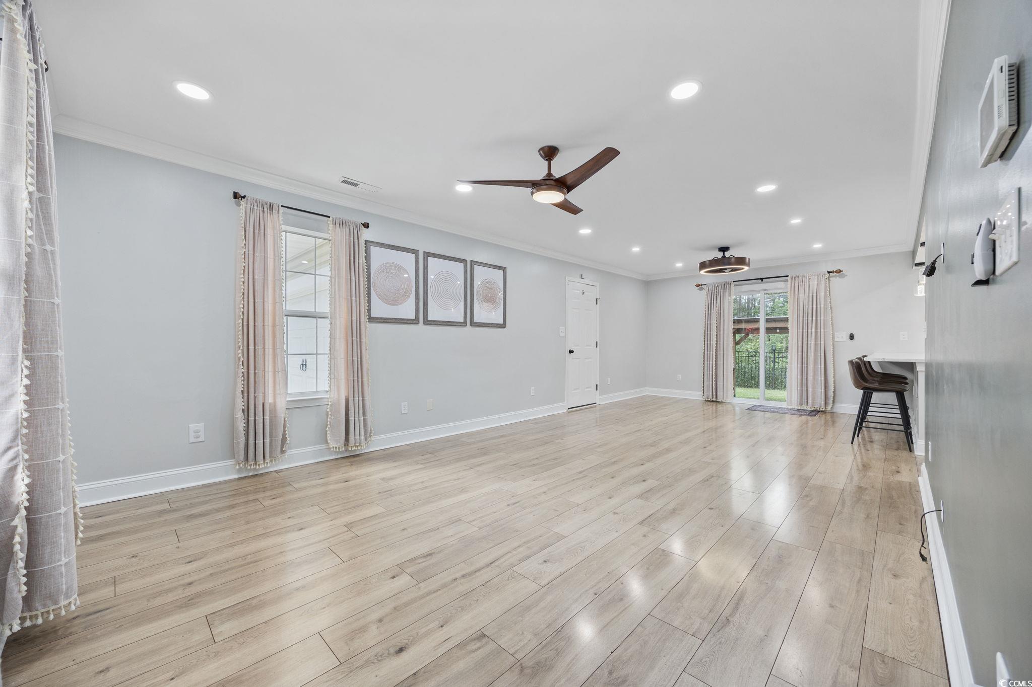 118 Sly Fox Trail Myrtle Beach, SC 29588 - Photo 7 of 40 Unfurnished living room featuring crown molding, ceiling fan, recessed lighting, and light wood-style floors