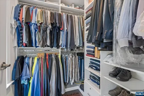 a view of walk in closet with clothes and shoes
