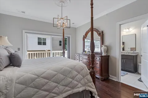 a bedroom with a bed chandelier and a window