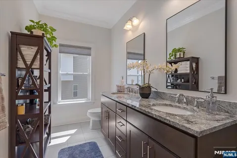 a bathroom with a granite countertop sink a toilet and mirror