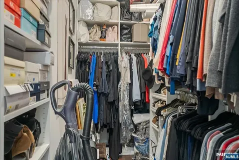 a view of walk in closet with clothes