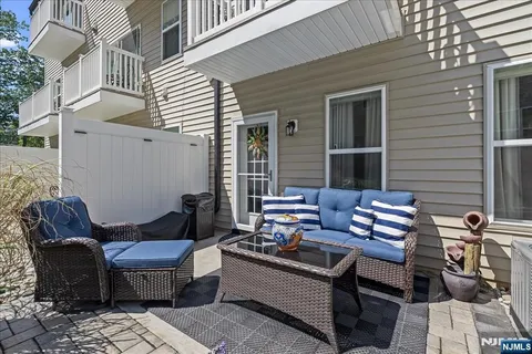 a view of a patio with couches and a dining table and chairs with wooden floor