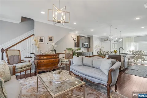 a living room with furniture kitchen view and a chandelier