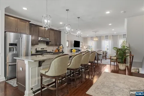 a large kitchen with kitchen island a dining table chairs and a refrigerator