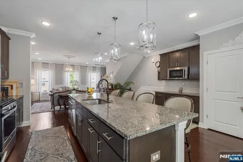 a kitchen with center island a sink stainless steel appliances and living room view