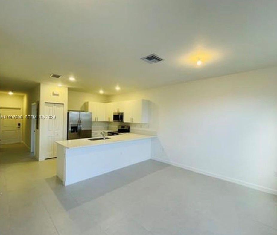 17907 Southwest 356th Street, Unit 17907 Homestead, FL 33034 - Photo 3 of 14 a view of a kitchen with a sink and a refrigerator