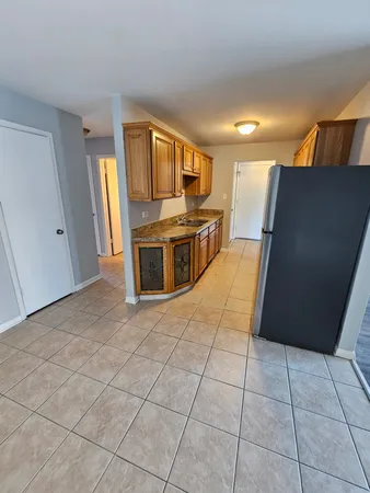 a view of a refrigerator in kitchen and a window