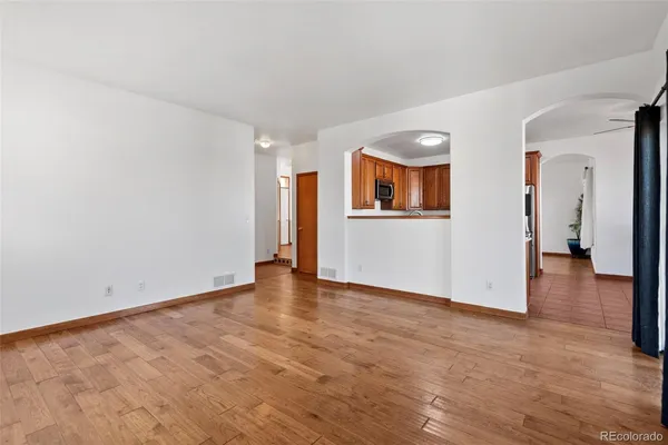 wooden floor fireplace and windows in an empty room