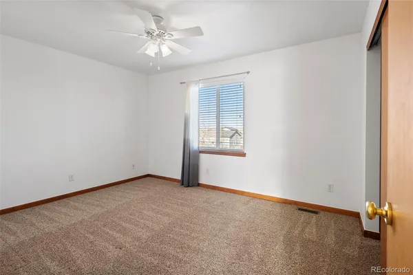 an empty room with a window and a ceiling fan