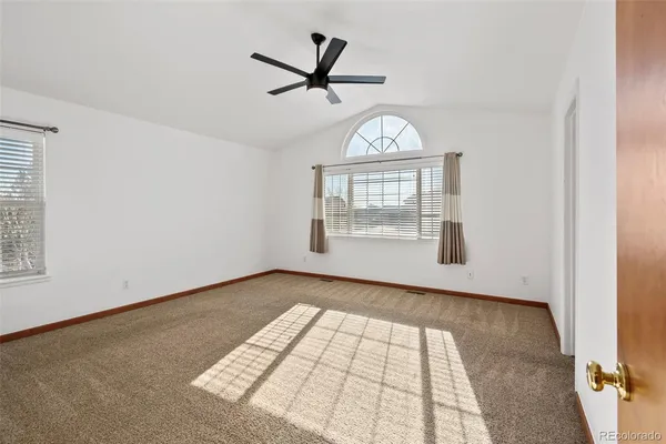 a view of a bedroom with wooden floor and a ceiling fan