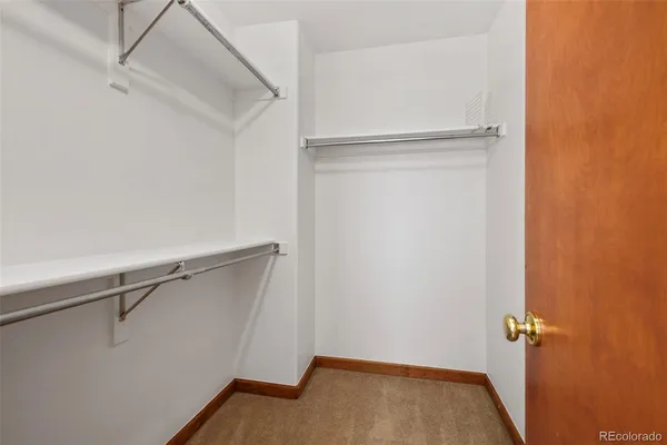 a view of an empty room with wooden floor and stairs
