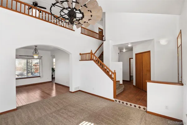 a view of an empty room with wooden floor and stairs