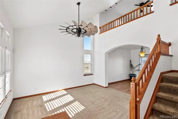 a view of an empty room with wooden floor and windows