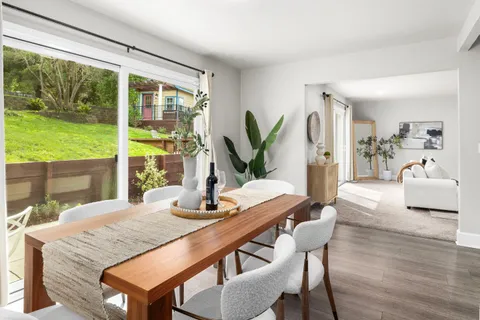 a dining room with furniture and a large window