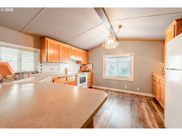 a view of a kitchen with wooden floor and a window