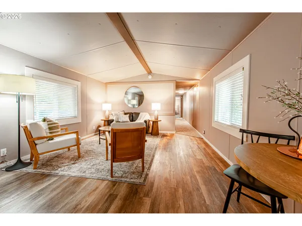 a living room with furniture a dining table and wooden floor