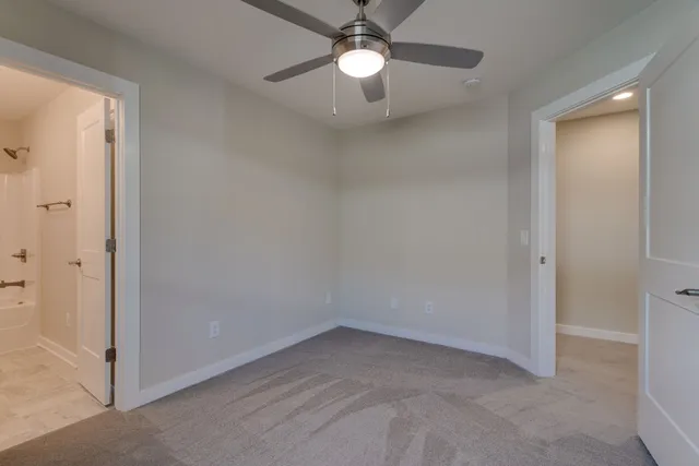 an empty room with closet and a chandelier fan