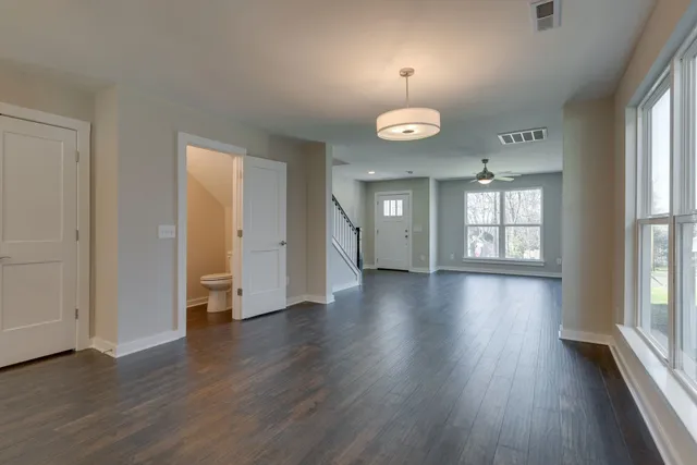 an empty room with wooden floor and window