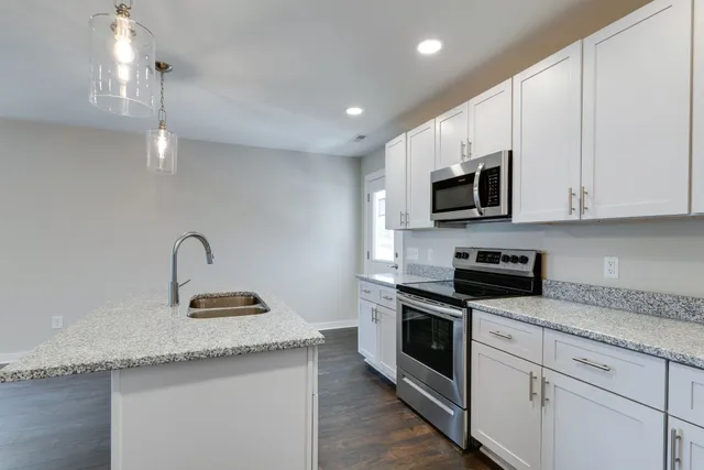 a kitchen with granite countertop a sink and steel appliances