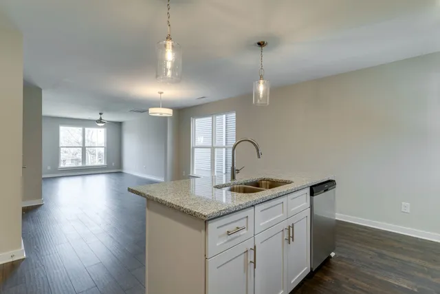 a kitchen that has a lot of white cabinets and wooden floor