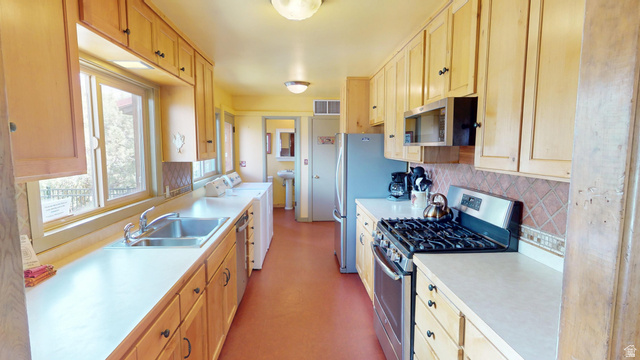 315 Abbey Road Moab, UT 84532 - Photo 15 of 46 Kitchen with stainless steel appliances, light wood finish cabinetry, light countertops, and tasteful backsplash