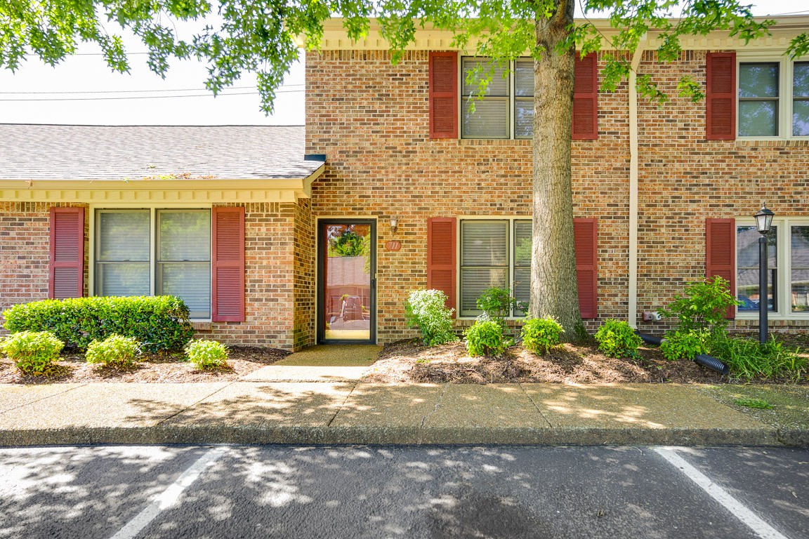 711 Kent Road Nashville, TN 37214 - Photo 1 of 31 a view of a brick house with many windows plants and large tree