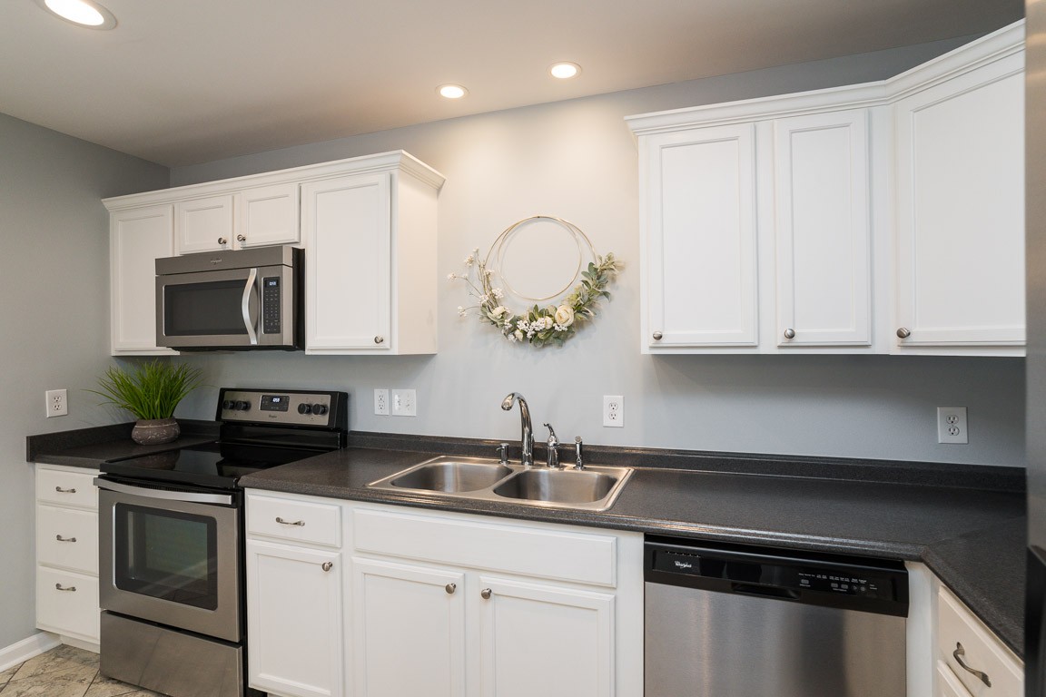 711 Kent Road Nashville, TN 37214 - Photo 12 of 31 a kitchen with white cabinets and black appliances