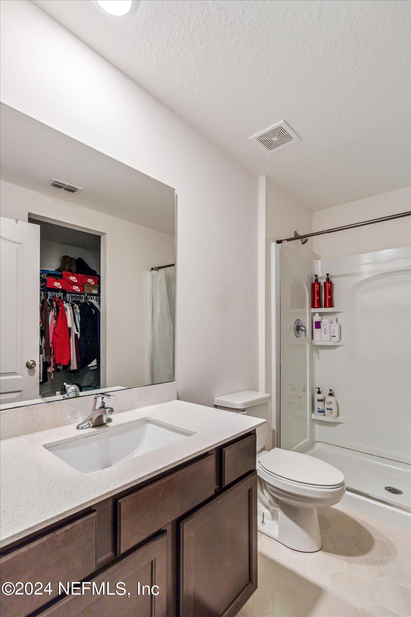 3 Pinwheel Lane Palm Coast, FL 32164 - Photo 12 of 20 a bathroom with a sink a toilet and a mirror