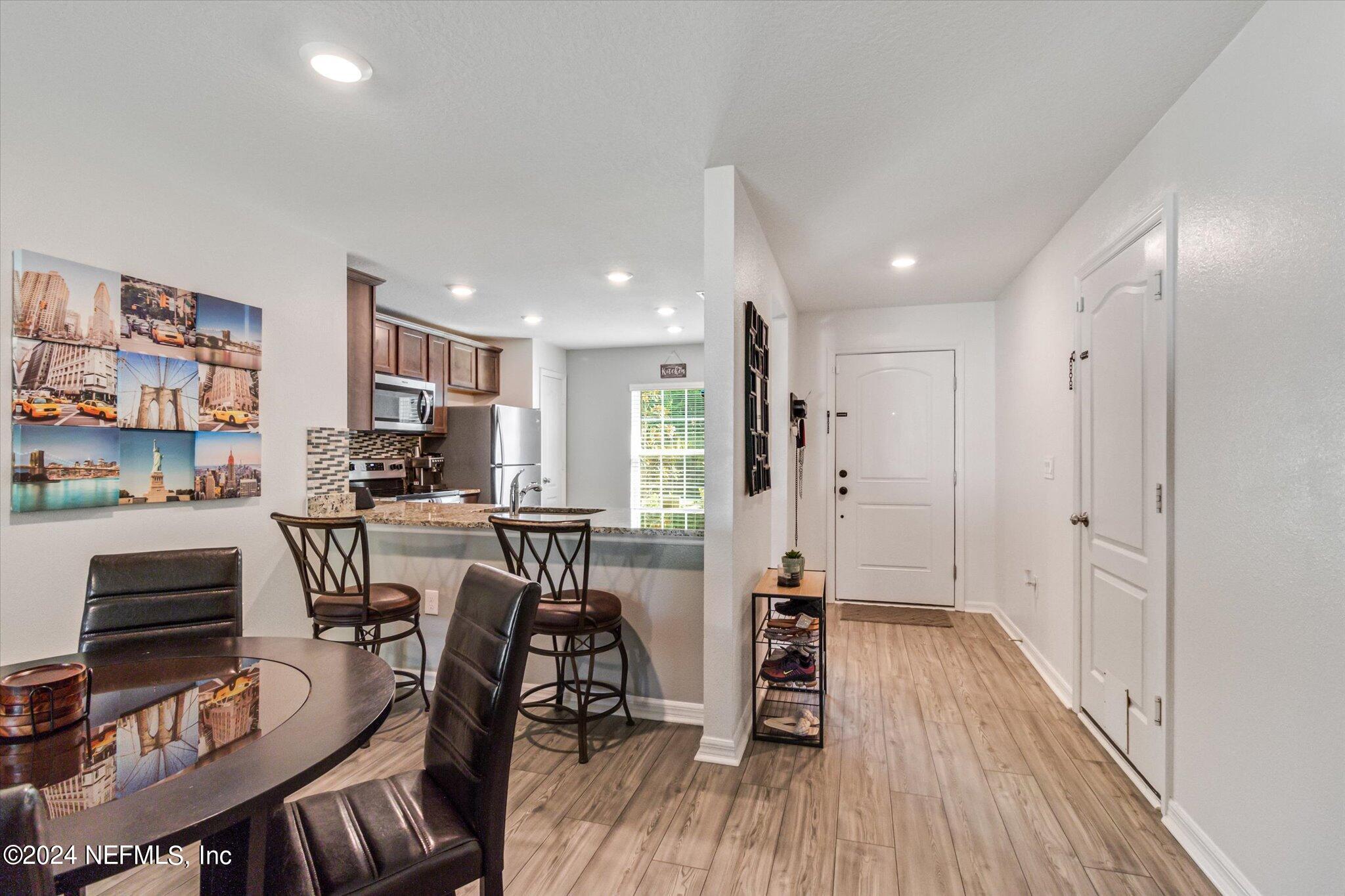 3 Pinwheel Lane Palm Coast, FL 32164 - Photo 6 of 20 a view of kitchen with stainless steel appliances refrigerator wooden floor dining table and chairs