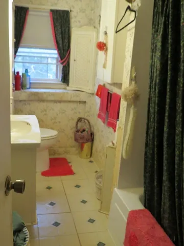 a bathroom with a tub sink and shower curtain