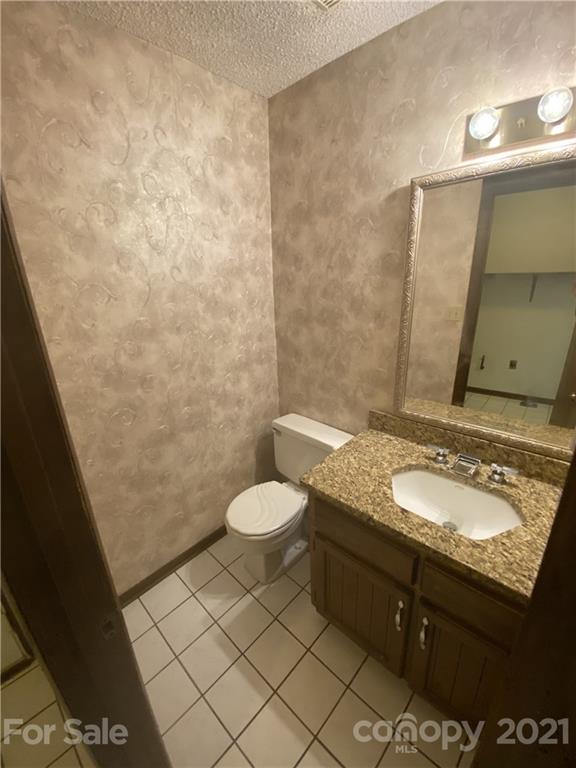 6205 Coldwater Court Raleigh, NC 27612 - Photo 14 of 16 a bathroom with a granite countertop sink and a mirror