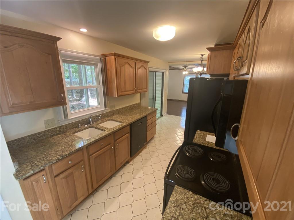 6205 Coldwater Court Raleigh, NC 27612 - Photo 3 of 16 a kitchen with granite countertop a refrigerator and a sink