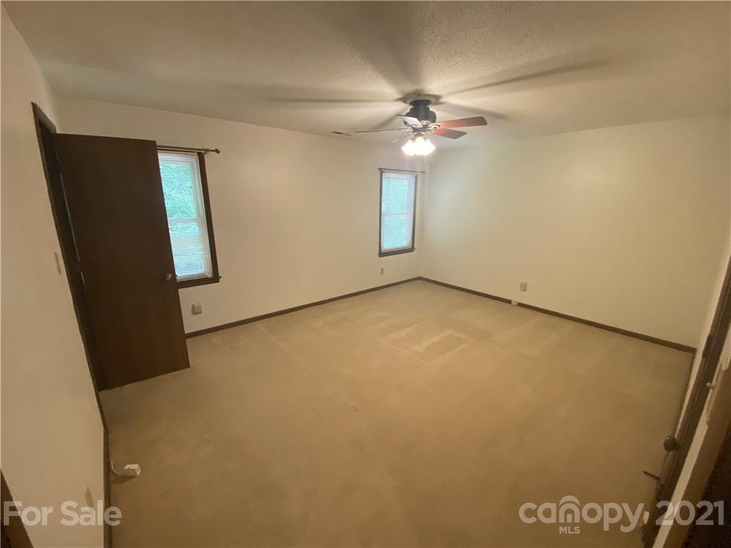 6205 Coldwater Court Raleigh, NC 27612 - Photo 8 of 16 an empty room with a chandelier fan and a large window