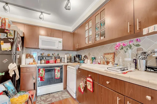 a kitchen with granite countertop lots of clutter and stainless steel appliances