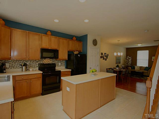 1635 Snow Mass Way Durham, NC 27713 - Photo 6 of 25 a large kitchen with stainless steel appliances a stove a refrigerator a sink a dining table and chairs