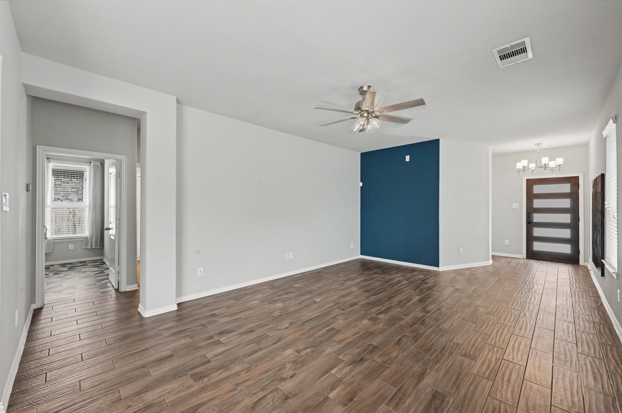 Alternate view of the living room showing the distinctive blue accent wall and updated front door with wood and frosted glass inserts.