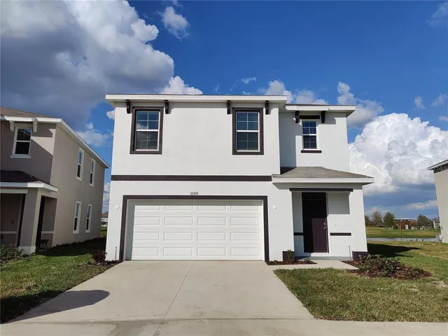 a front view of a house with a yard and garage