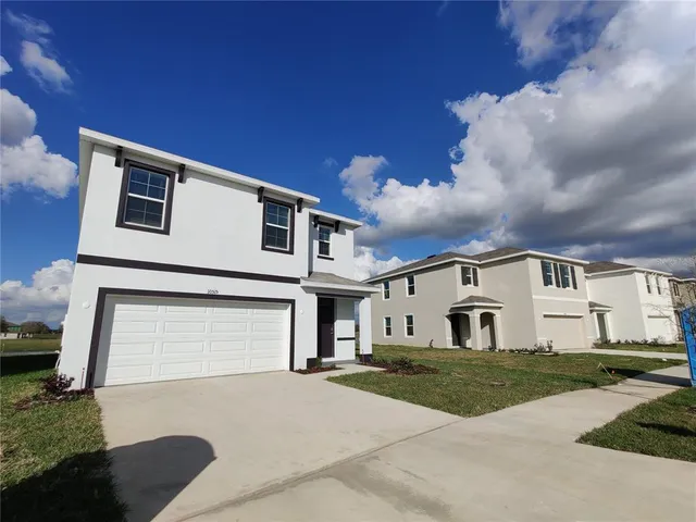 a view of a white house with a yard
