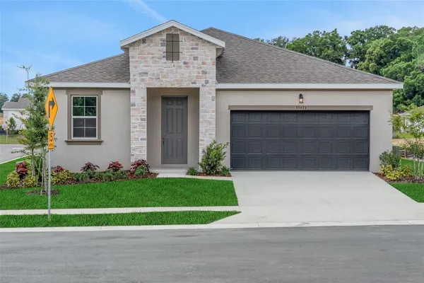 a front view of a house with a yard and garage