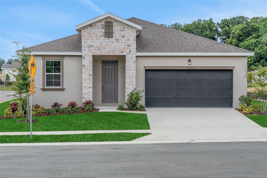 35424 Tuscan Hill Road Dade City, FL 33525 - Photo 1 of 42 a front view of a house with a yard and garage
