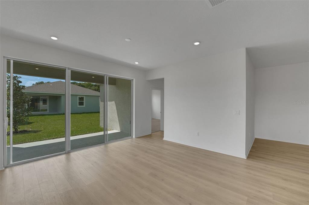 35424 Tuscan Hill Road Dade City, FL 33525 - Photo 20 of 42 a view of an empty room with wooden floor and a window