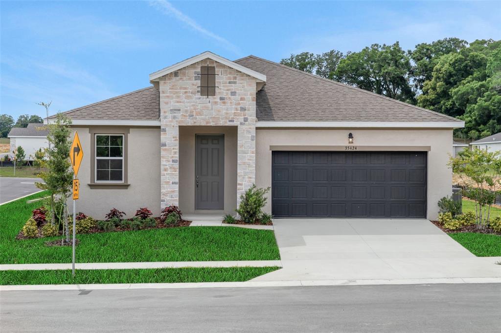 35424 Tuscan Hill Road Dade City, FL 33525 - Photo 2 of 42 a front view of a house with a garden and plants