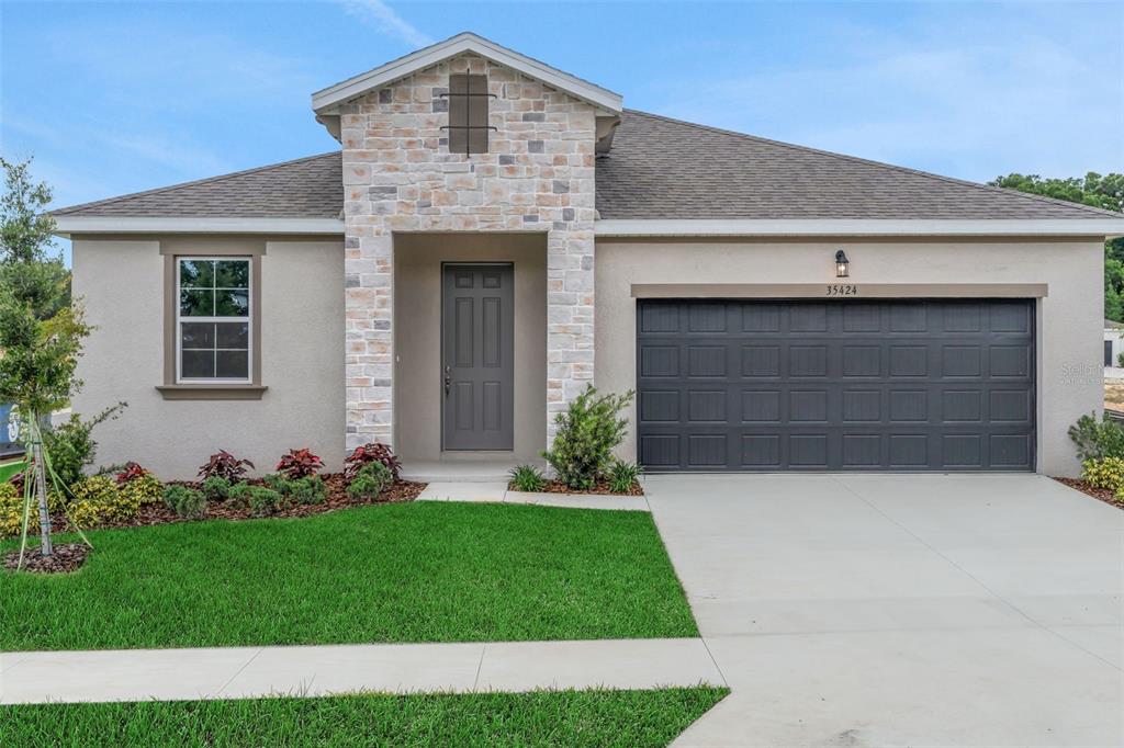 35424 Tuscan Hill Road Dade City, FL 33525 - Photo 3 of 42 a front view of a house with a yard and garage